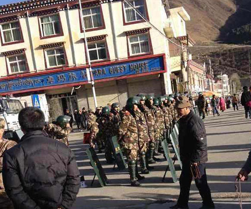 Armed police in riot gear block a road near the site of the self-immolation. Armed police in riot gear block a road near the site of the self-immolation.