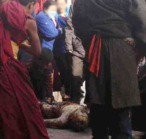 A women looks at the burned body of Dorje Rinchen following his self-immolation. A women looks at the burned body of Dorje Rinchen following his self-immolation.