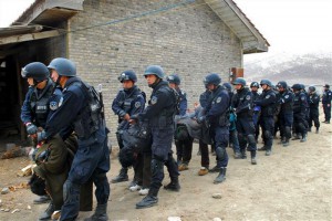 Tibetans being dragged away, bent double, by People's Armed police in riot gear. Tibetans being dragged away, bent double, by People's Armed police in riot gear.