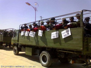 Monks bent double across the side of an open army truck, still with the placards announcing their "splittist" activities around their necks. Monks bent double across the side of an open army truck, still with the placards announcing their "splittist" activities around their necks.